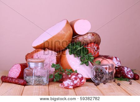 Lot of different sausages on wooden table on beige background
