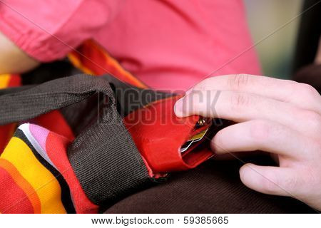 Pickpocket are stealing wallet from bag, close up