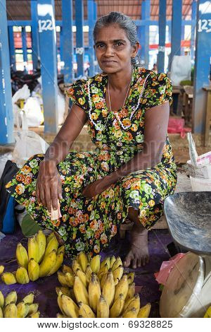 HIKKADUWA, SRI LANKA - MARCH 9, 2014: Local female vendor selling bananas. The Sunday market is a fantastic way to see Hikkaduwa's local life come alive along with fresh produce and local delicacy