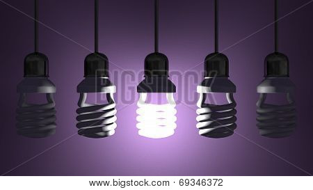 Glowing Spiral Light Bulb Hanging Among Dead Ones