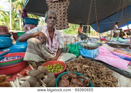 HIKKADUWA, SRI LANKA - FEBRUARY 23, 2014: street vendor selling fresh ginger and containers. The Sunday market is a fantastic way to see Hikkaduwa's local life come alive.