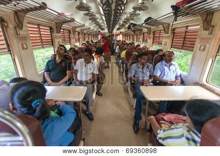 HIKKADUWA, SRI LANKA - FEBRUARY 22, 2014: Local commuters sit in train to Colombo. Trains are very cheap and poorly maintained but it's the best option to witness a bit of everyday local life.