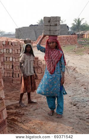 SARBERIA,INDIA, JANUARY 16: Brick field workers carrying complete finish brick from the kiln. Tools and machines for making bricks are very rudimentary, Jan 14, 2009 in Sarberia, West Bengal, India.