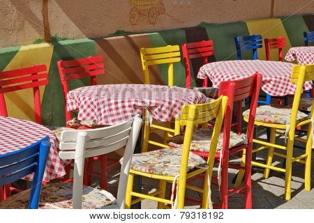 colorful chairs and tables with red checked tablecloth in a street of Novi Sad, Serbia