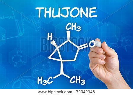 Hand with pen drawing the chemical formula of thujone