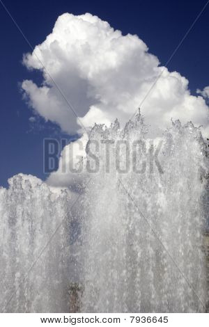 Fountain Against The Sky And A Cloud