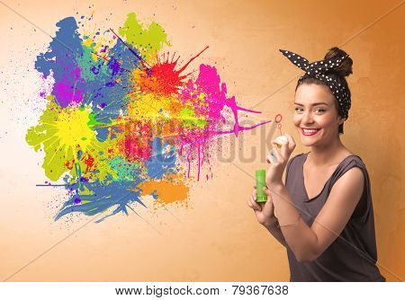 Cute girl blowing bubble spalsh graffiti into wall