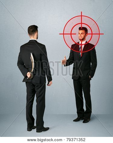 Ruthless businessman handshake with a hiding weapon and a head target point 