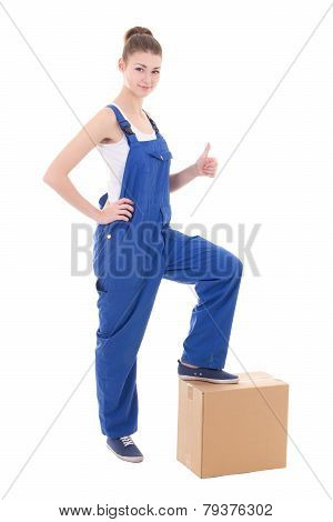 Moving Day Concept - Young Attractive Woman In Blue Coveralls With Cardboard Box Isolated On White