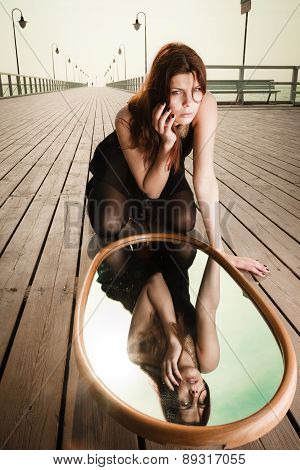 Thoughtful Woman Looks At Reflection In Mirror