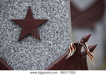 Red star and the Ribbon of Saint George at the Soviet War Memorial with graves of Soviet soldiers fallen in the last days of World War II at the Olsany Cemetery in Prague, Czech Republic.