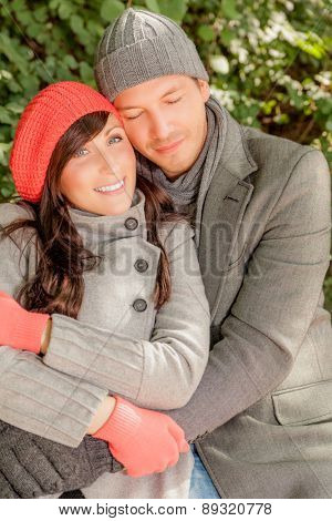 embracing couple sitting colder day outdoors