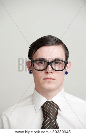 Portrait - Young Man With Eye Glasses & Pierced Ears Wearing Business Shirt & Neck Tie