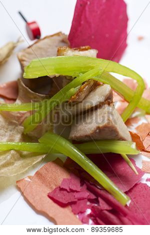 Closeup of a skewer of pork jowls.