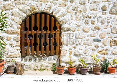 Wooden bars door, in an old medeval building and part of the stone made wall