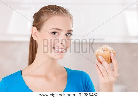 Upbeat girl holding muffin