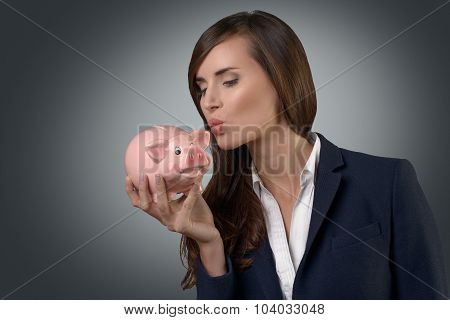 Successful Businesswoman Kissing Her Piggy Bank