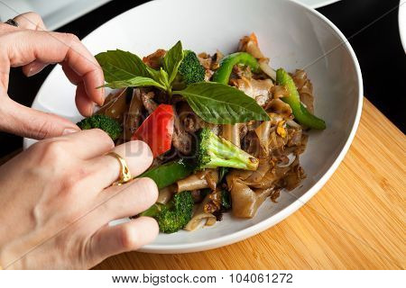 Food Stylist Garnishing a Dish