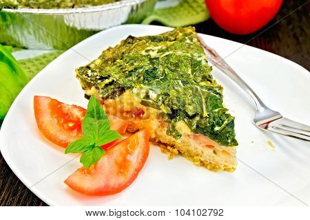 Pie celtic with spinach and tomatoes on table
