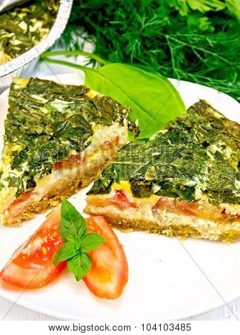 Pie celtic with spinach and tomato in plate on board