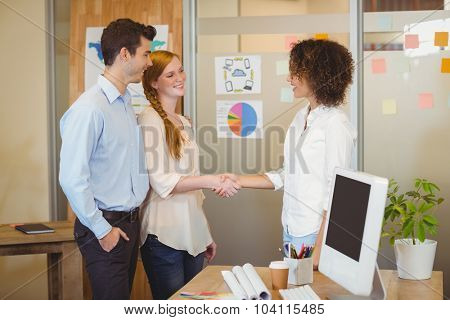 Business woman shaking hand with client in office