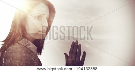 Depressed businesswoman looking away against trees and mountain range against cloudy sky