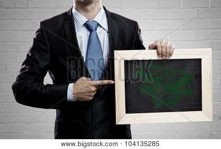 Unrecognizable businessman holding blackboard with drawn money concept