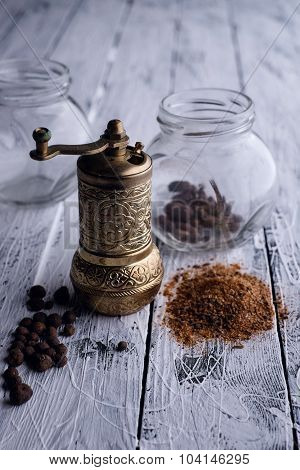 Vintage Still Life With Brass Pepper Mill Standing On The Wooden Background.