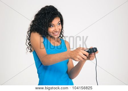 Portrait of a happy afro american woman playing in video game with joystick isolated on a white background