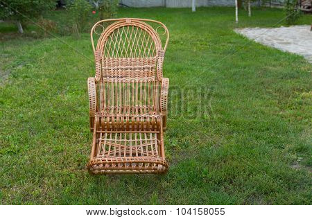 Empty wicker rocking-chair in the garden