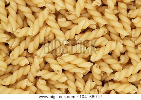 dry uncooked thick gemelli pasta texture background