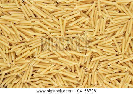 dry uncooked penne lisce pasta texture background