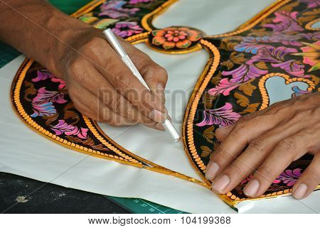 Malaysian kite maker working on a kite in his workshop