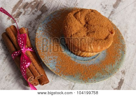 Muffins With Plums And Powdery Cinnamon, Cinnamon Sticks On Old Wooden Background, Delicious Dessert