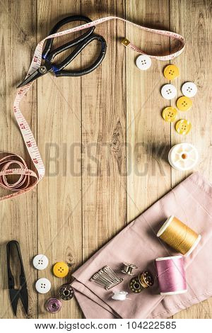 Sewing tools and sewing kit on wooden textured background