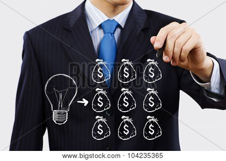 Close up of businessman drawing money making formula