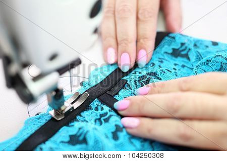 Sewing on a machine.
