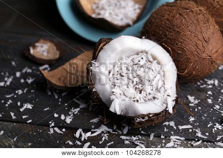 Coconut shavings in coconut on wooden background
