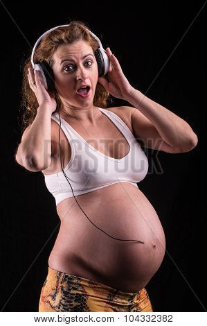 pregnant woman with headphones listening