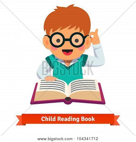 Small boy playing in glasses reading book