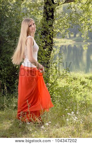 Beautiful Young Blonde Woman Dancing In Forest On Riverbank