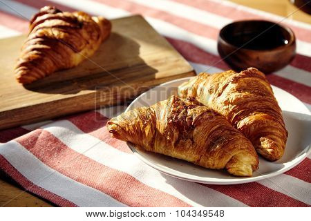 French Breakfast With Three Croissant And Honey On Red White Stripe Cloth