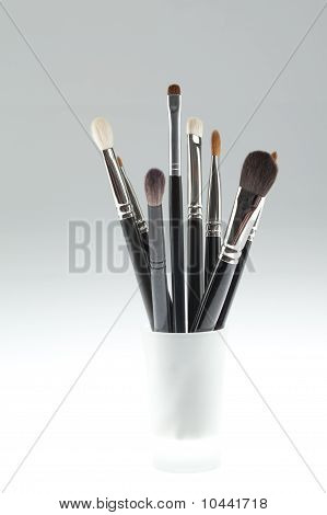 A Set Of Make-up Brushes Set In A Small Glass