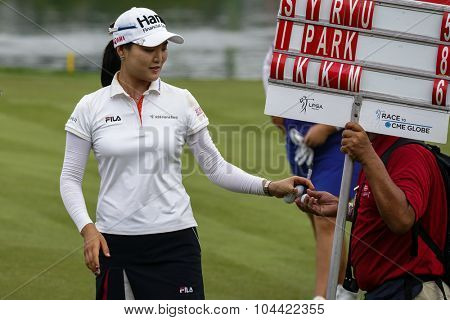 KUALA LUMPUR, MALAYSIA - OCTOBER 09, 2015: South Korea's So Yeon Ryu passes an autographed golf ball to a volunteer after finishing her day's play at the 2015 Sime Darby LPGA Malaysia golf tournament.