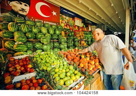 Man chooses peaches on a market stand in Istanbul