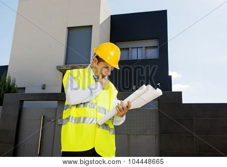 Young Attractive Foreman Worker Supervising Building Blueprints Outdoors Wearing Construction Helmet
