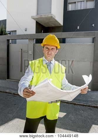 Young Attractive Foreman Worker Supervising Building Blueprints Outdoors Wearing Construction Helmet