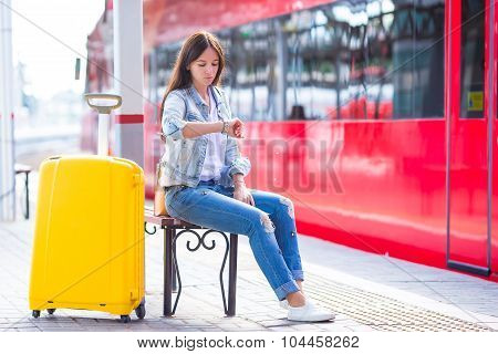 Young woman with luggage on train platform waiting for aeroexpress