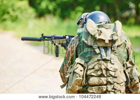 military. two soldier with assault rifle in uniform patrolling territory outdoors