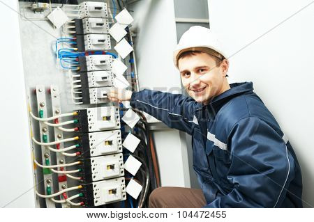 electrician builder engineer inspector checking data of equipment in fuse box
